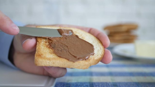 Hungry Man Prepare for Breakfast a Roasted Slice of Bread with Chocolate Cream