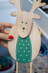Naklejka premium Wooden deer in the arms