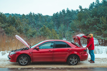 car with opened hood man looking in trunk