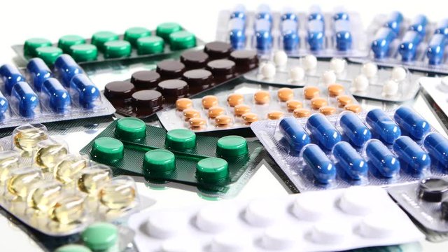 Colorful contraceptive pills, rotation, reflection, close up, on white