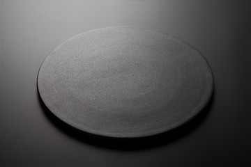 Empty black plate on black background