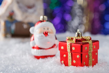 Christmas composition with toy gift box and Santa Claus on artificial snow