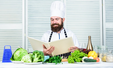 Cooking by recipe. Happy bearded man. chef recipe. Dieting organic food. Healthy food cooking. Mature hipster with beard. Vegetarian salad with fresh vegetables. Cuisine culinary. Vitamin