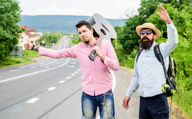 Travel by autostop. Hopeless hitchhiker. Company friends looking for transport. Men try stop car....