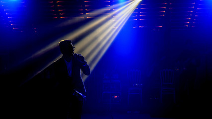 Fototapeta na wymiar close up photo the silhouette of a singer in dark concert spotlights