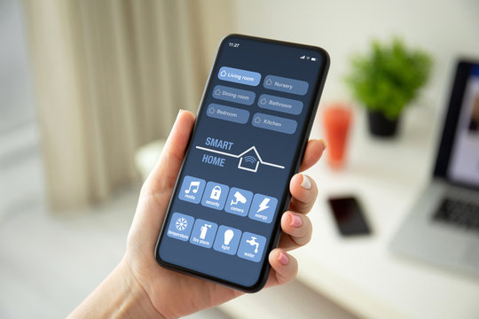 female hands holding phone with app smart home on screen