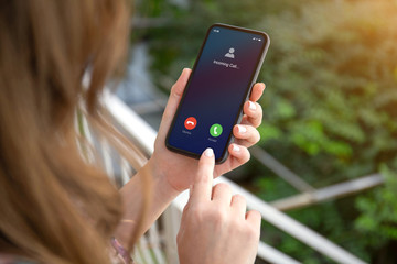 female hands holding phone with incoming call on the screen