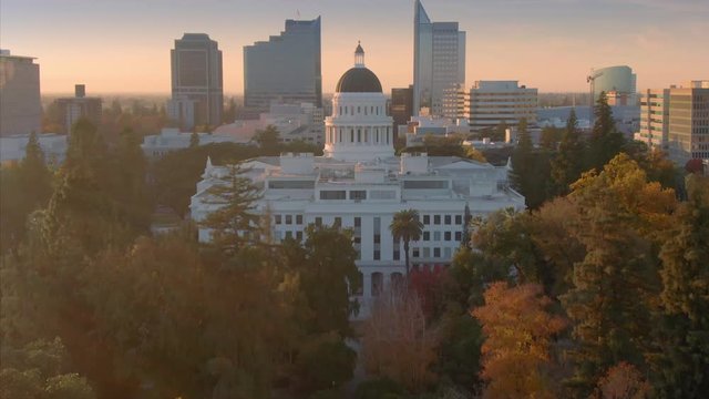 Aerial: flying over California State Capitol building and park at sunset. Sacramento, California, USA. 11 November 2019.