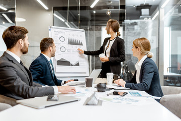 Business people discussing some financial issues, speaker giving a presentation on a small conference in the meeting room