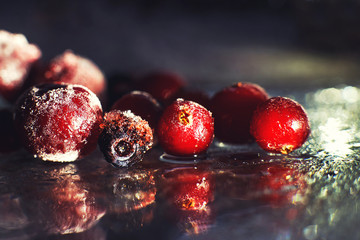 closeup frozen berries on the glass with reflection . frozen berries  on a dark background macro. cranberries blueberries and cherries