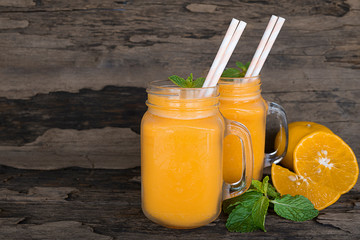 Naklejka na ściany i meble Orange juice fruit smoothies yogurt drink yellow healthy delicious taste in a glass slush for weight loss on wooden background.