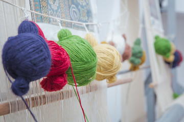 Various yarn on weaving handmade carpet . manual production of carpets .round wooll yarn . ball...
