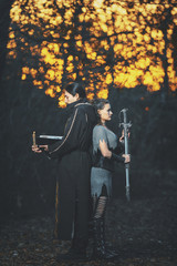 A man with long hair and beard in a black cloak and hood in the form of a sorcerer warlock and a...