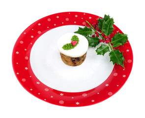 Mini Christmas fruit cake on a large festive decorated plate isolated on a white background