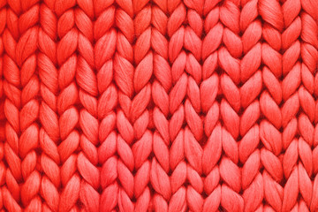 Texture of red wool big knit blanket. Large knitting. Plaid merino wool. Top view