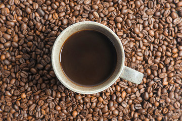 One cup of coffee on the coffee beans background. Flat lay,