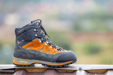 A leather trekking hiking winter boot on blurred background