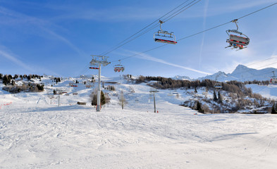 Fototapeta na wymiar skiers on chairlifts in alpine resort at winter sports