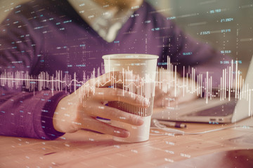 Forex graph with businessman working on computer in office on background. Concept of hardworking....