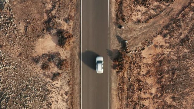 Desert road aerial with cars driving below high shot