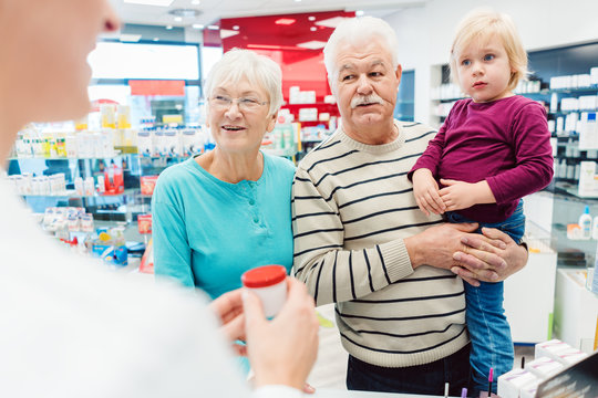 Grandparents in pharmacy buying prescription drugs for grandchild