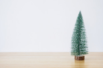 christmas tree on wood table with white wall background