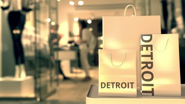 Paper shopping bags with Detroit caption against blurred store entrance. Retail in the United States related conceptual 3D animation