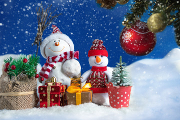 Snowman in a snowdrift with gifts for Christmas and New year
