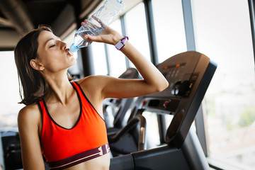 Fototapeta premium Tired exhausted woman relaxing after a fitness training in gym