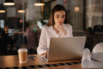 Young businesswoman in office. Beautiful female architect working late night.