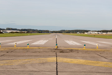 OBERPFAFFENHOFEN, BAVARIA / GERMANY - September 28, 2019: Centered view on an empty runway / landing strip. An airfield of an airport close to Munich. Concept for journey, travel, fly away, freedom, d