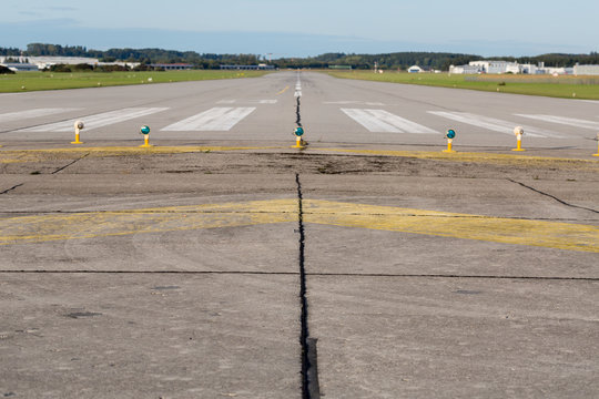 OBERPFAFFENHOFEN, BAVARIA / GERMANY - September 28, 2019: Straight view on empty runway / landing strip of a small airport near Munich. White markings on grey asphalt. Ready for take off and landing. - Powered by Adobe