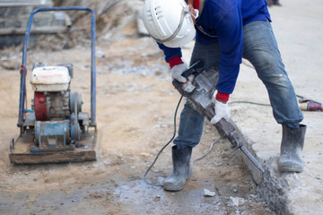 Workers are using the tools to extract the excess cement to the pattern. With white cloth gloves Blue shirt, jeans, small side plate in construction area