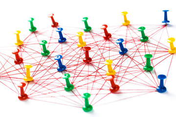 Network with colorful pins and string,  linked together with string on a white background suggesting a network of connections.