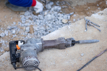 A tool to extract the cement from the floor after use. Placed beside the small steel scrap, In the area of building construction background have worker keeping scrap.