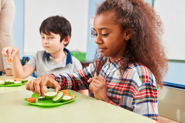 Mädchen isst Gemüse als Pausensnack