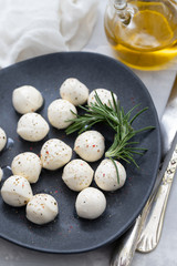 mozarella with pepper on black plate on ceramic background