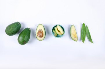 whole and cut avocado on white background