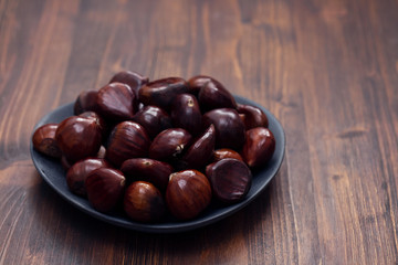 beautiful raw brown chestnuts in dark dish