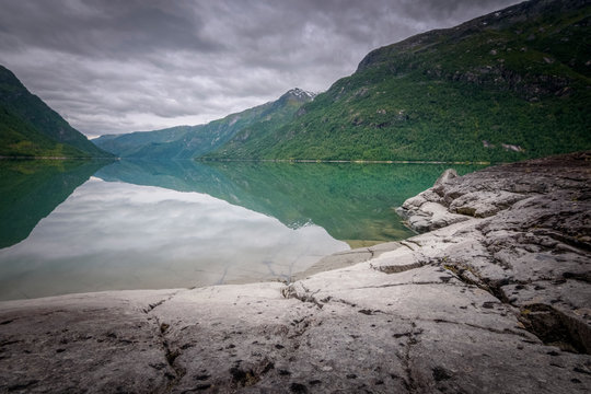 Stone cracks leading into the dept of the turquoise mountain lake Norway