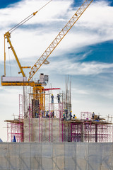 Aerial view of a building construction site in progress with tower crane, scaffolding, formwork,...