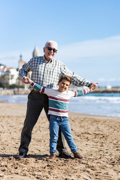 Grandfather and grandson playing at Sitges beach