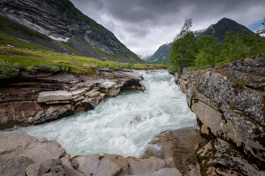 Wild fast glacial river in harsh and rocky mountain landscape Norway
