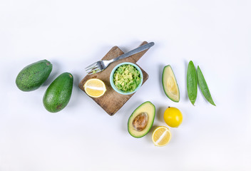whole and cut avocado on white background