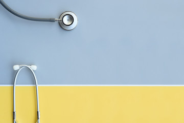 close up of stethoscope on gray and yellow background     