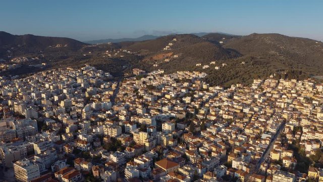 Aerial drone Flight descending to downtown mitilini, houses on hills and mountains, mytilene lesvos, greece