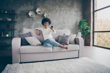 Photo of pretty dark skin wavy lady homey mood holding tv remote control changing channel searching...