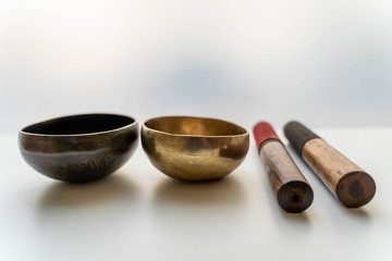 Bronze singing bowls with clappers on white background for meditation or massage (shallow depth of...