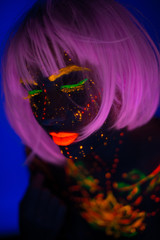 Portrait of Beautiful Fashion Woman in Neon UF Light. Model Girl with Fluorescent Creative Psychedelic MakeUp, Art Design of Female Disco Dancer Model in UV, Colorful Abstract Make-Up. Dancing Lady