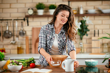 Obraz na płótnie Canvas Young woman in kitchen. Beautiful woman preparing healthy food.